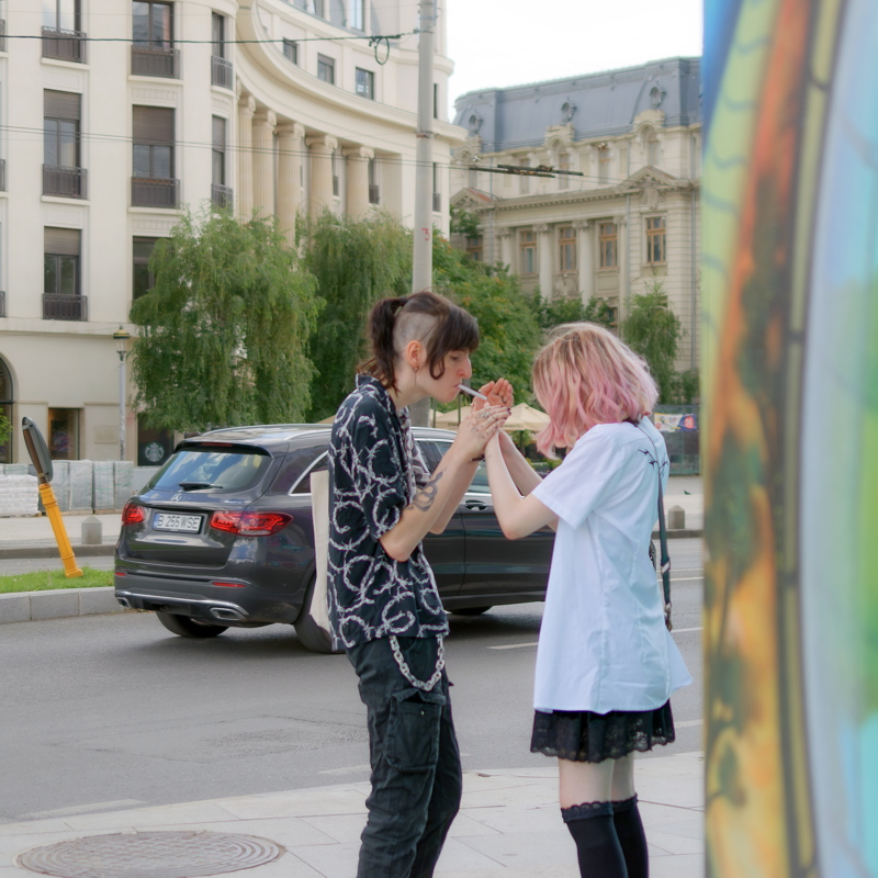 14 - Scene featuring individuals in alternative fashion with one person wearing a patterned top and another in a white t-shirt